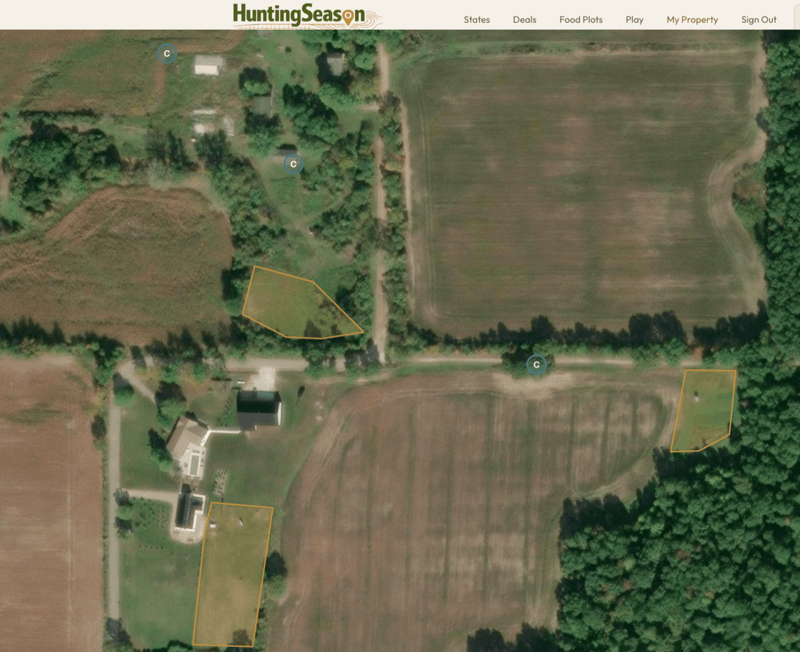 Satellite map view of a hunting property with food plot polygons and trail camera pins